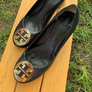 Tory Burch black shoe w/gold logo on toe and a gold band on the heel.